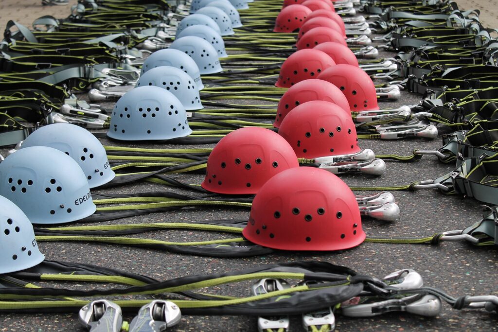 Helm, Klettergurt und Klettersteigset liegen am Einstieg auf einem Felsblock bereit