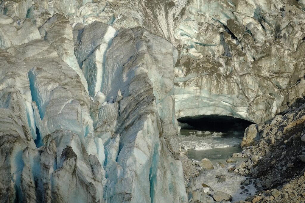 Glatte, bläulich schimmernde Eisfläche eines Gletschers mit feinen Schmelzrinnen
