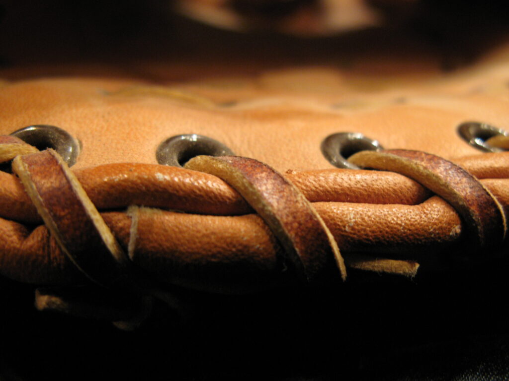 Behandschuhte Hand greift ein Stahlseil, die Lederinnenfläche ist dunkel und abgegriffen