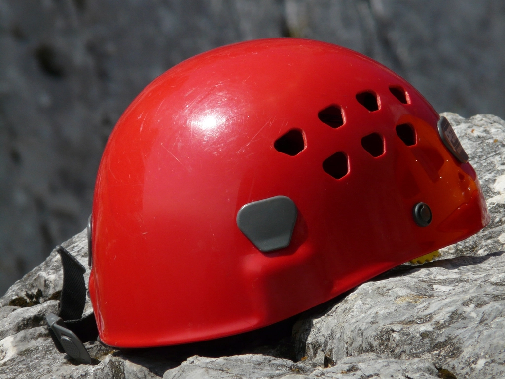 Kletterhelm wird von Hand auf Risse und Druckstellen an der Au&szlig;enschale untersucht